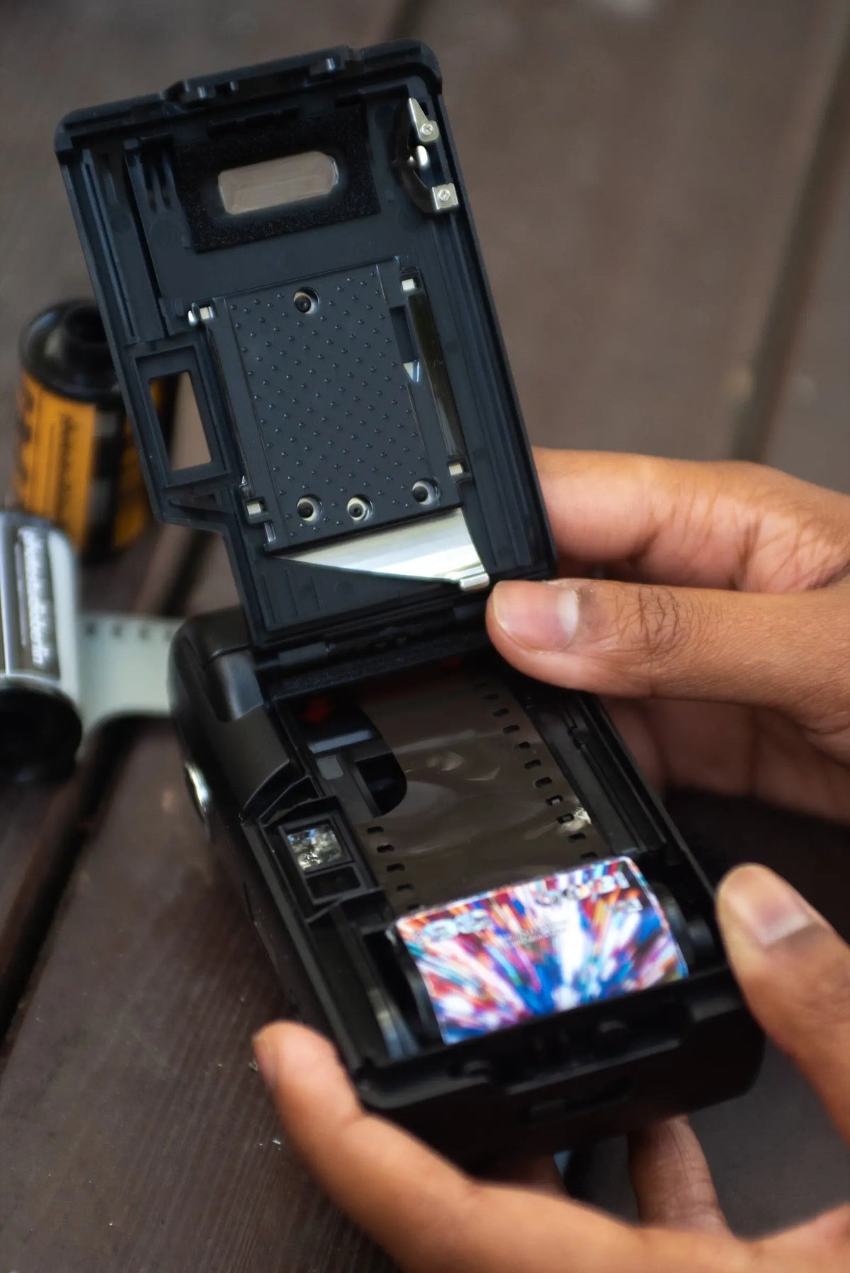 Loading a 35mm film roll into a compact camera