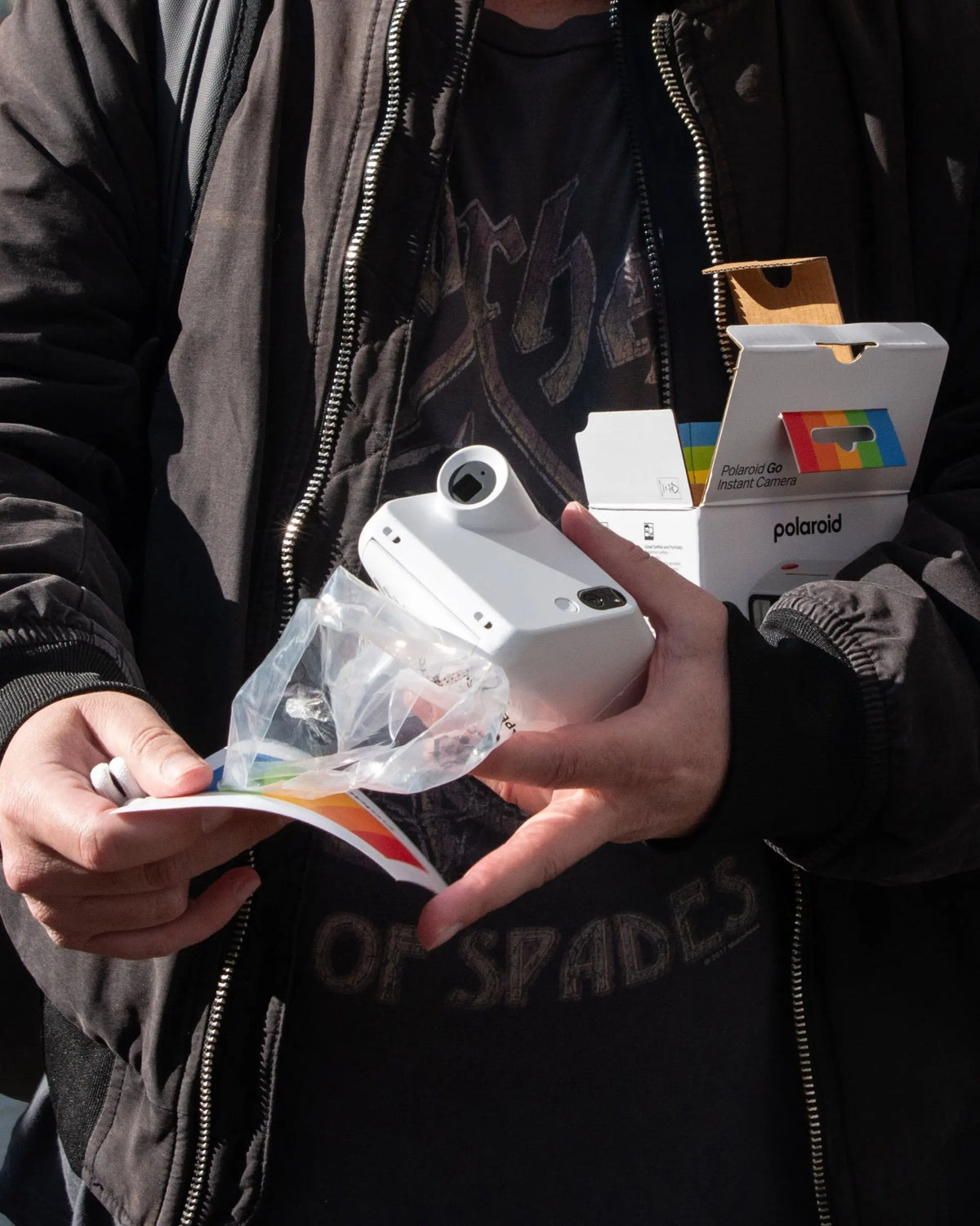 Unpacking instant film beside a white camera