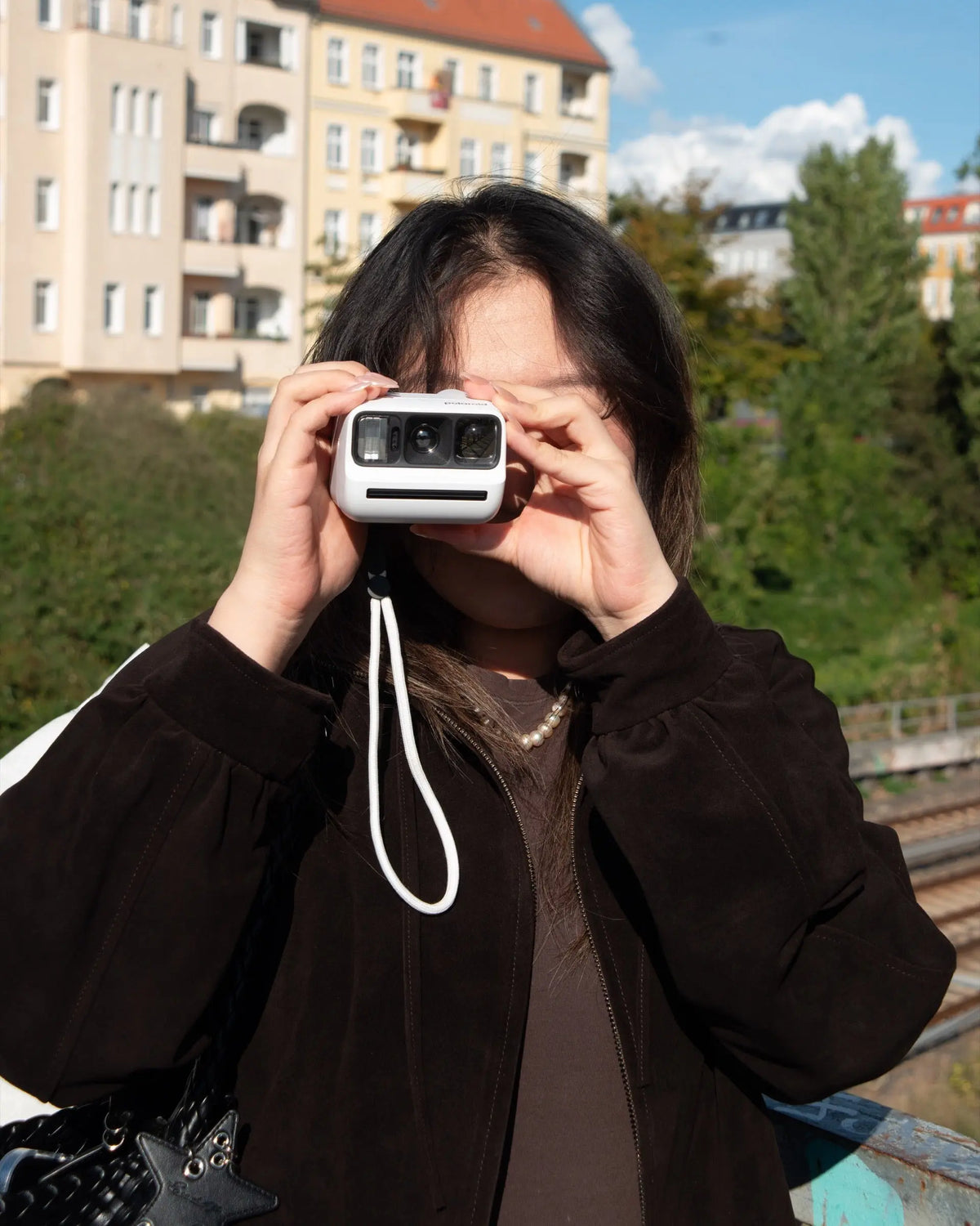 Photographer composing an outdoor picture with a compact camera