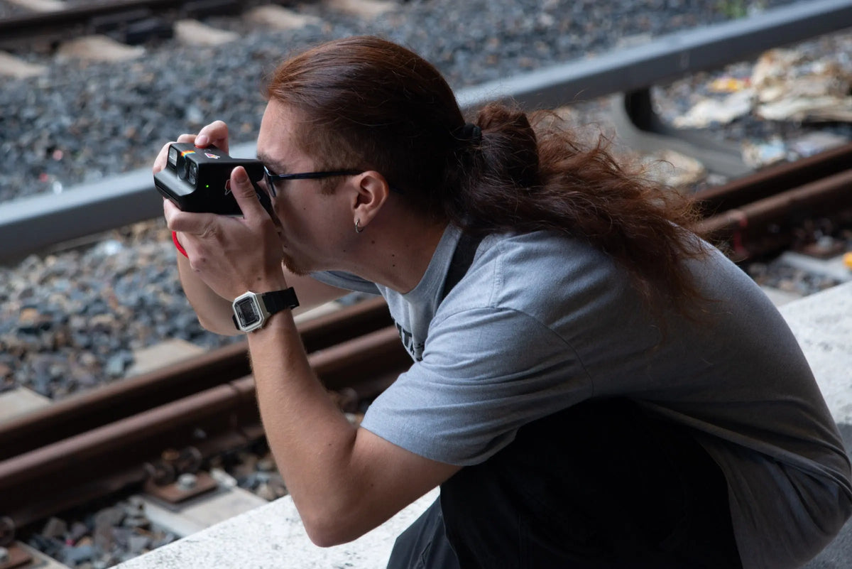 Photographer crouching to compose an outdoor photograph