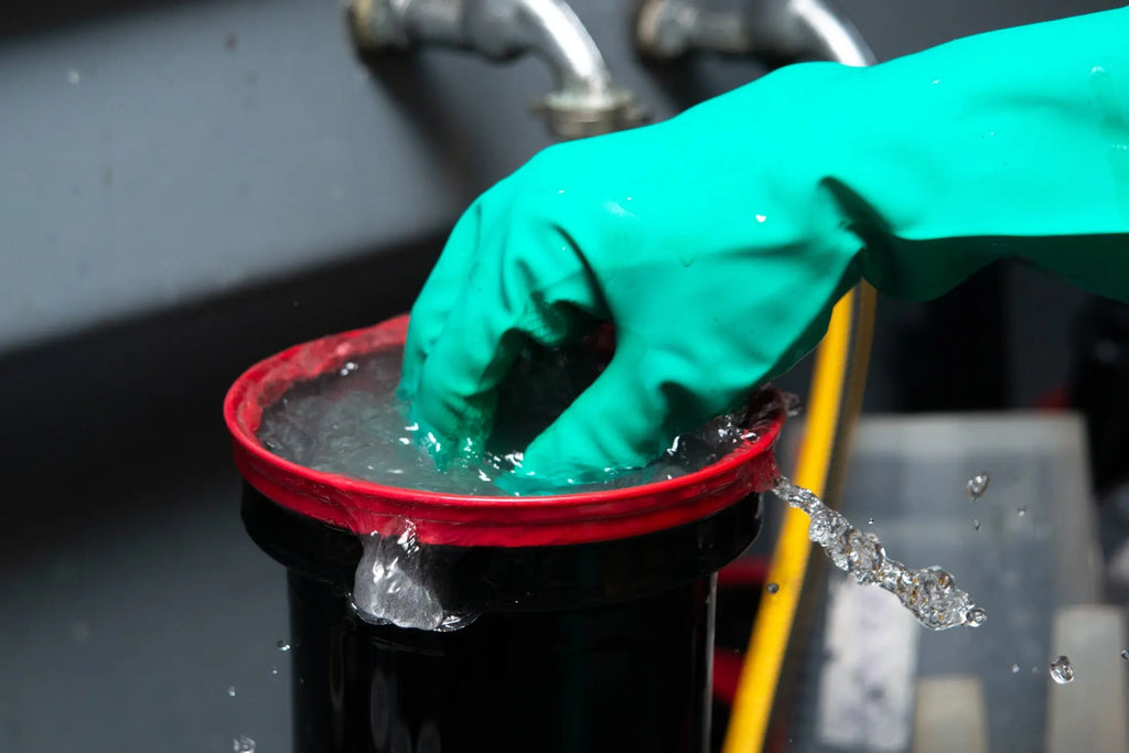 Close-up of a gloved hand rinsing a development tank at Berlin Photo Studio