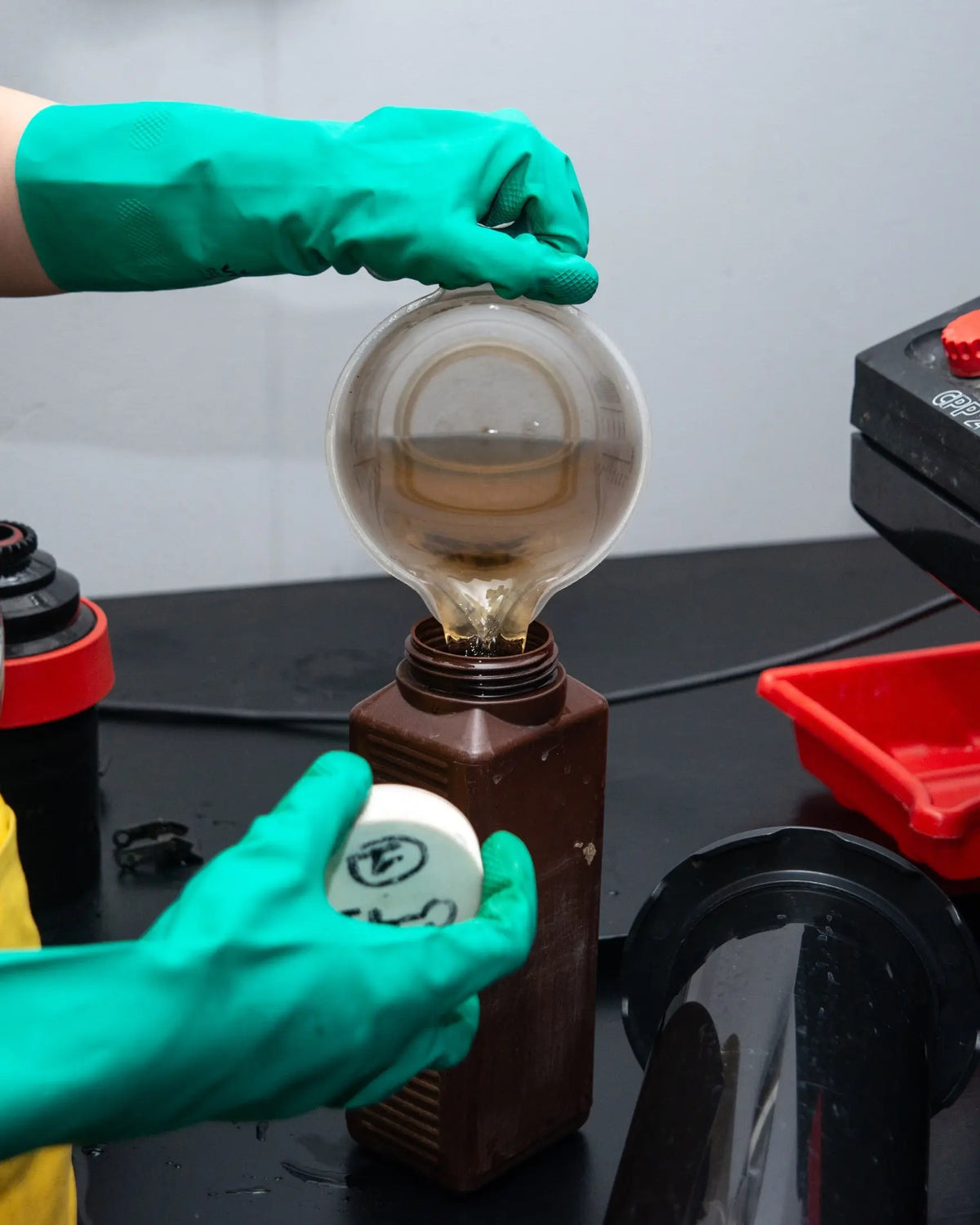 Measured processing solution being returned to a labelled bottle at Berlin Photo Studio